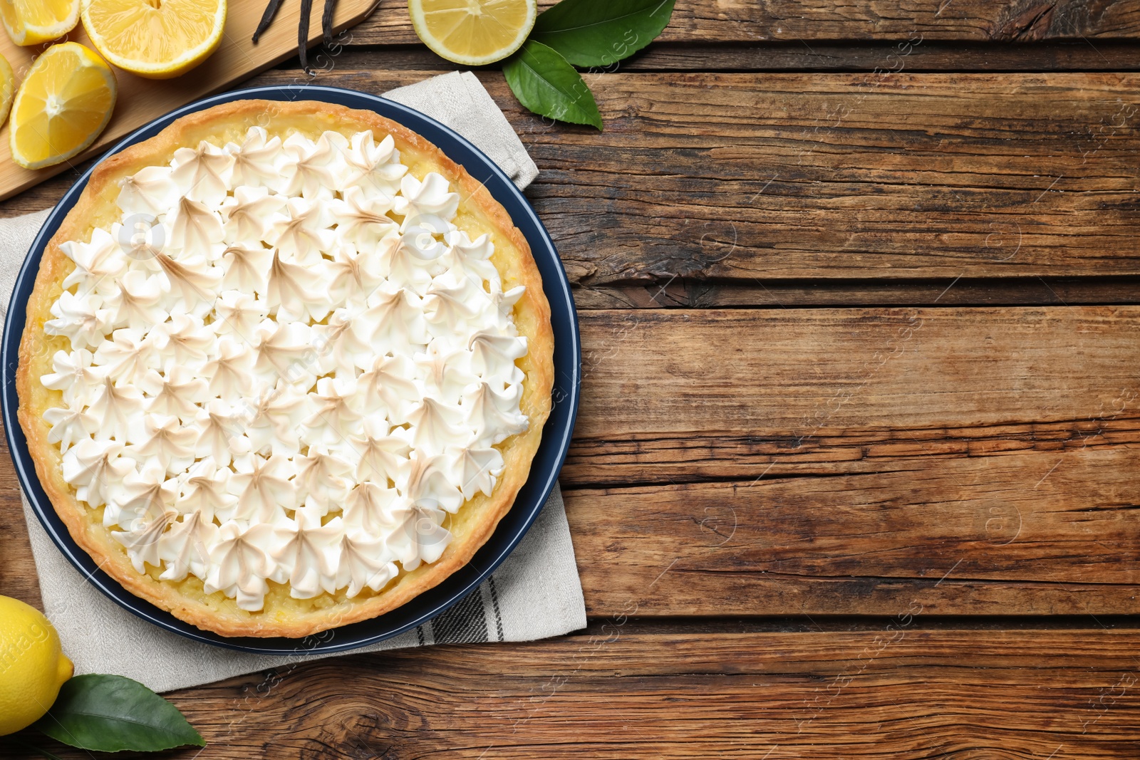 Photo of Flat lay composition with delicious lemon meringue pie on wooden table. Space for text