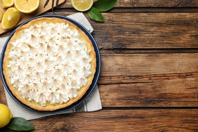 Flat lay composition with delicious lemon meringue pie on wooden table. Space for text