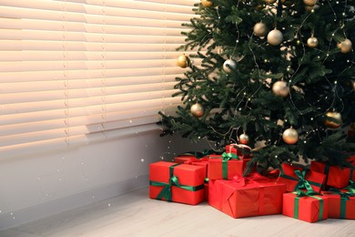 Beautifully wrapped gift boxes under Christmas tree in living room. Space for text