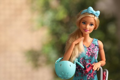 Photo of Mykolaiv, Ukraine - September 4, 2023: Beautiful Barbie doll with helmet on blurred background, space for text