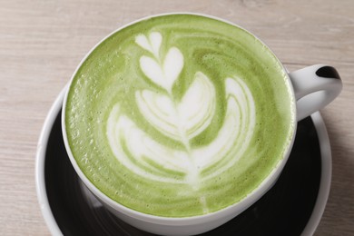 Photo of Cup of fresh matcha latte on table, closeup