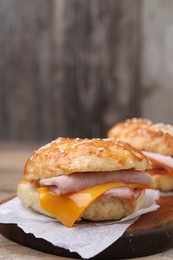 Photo of Delicious bagels with ham and cheese on table