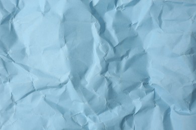 Photo of Sheet of crumpled light blue paper as background, top view