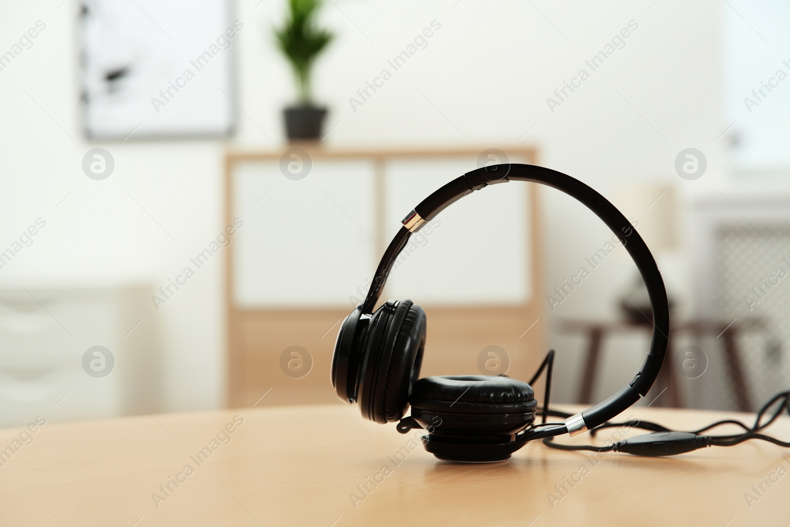 Photo of Stylish headphones on table indoors. Space for text