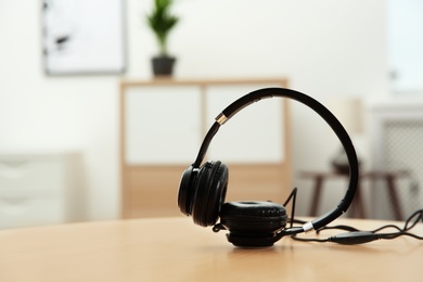 Photo of Stylish headphones on table indoors. Space for text