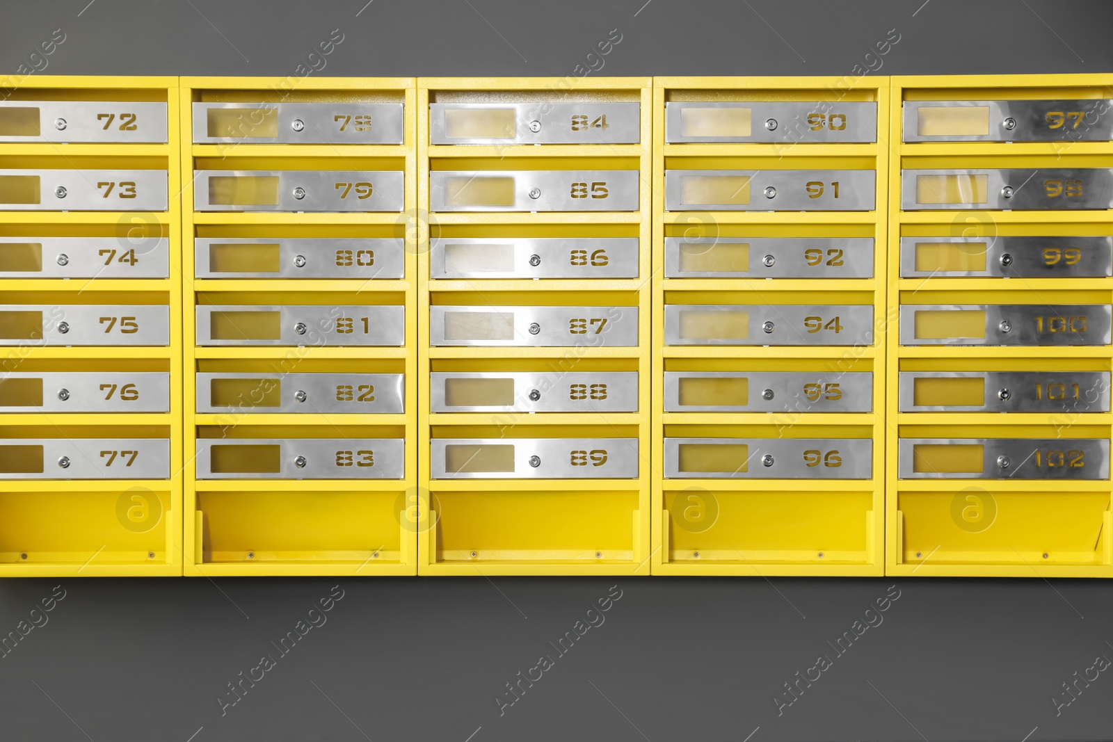 Photo of Many closed metal mailboxes with keyholes and numbers in post office