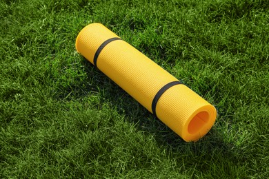 Photo of Bright exercise mat on fresh green grass outdoors