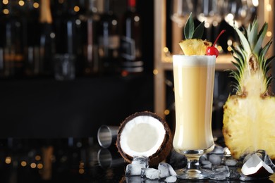 Photo of Tasty Pina Colada cocktail and ingredients on bar countertop, space for text