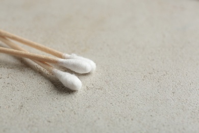 Cotton swabs on grey background, closeup. Space for text