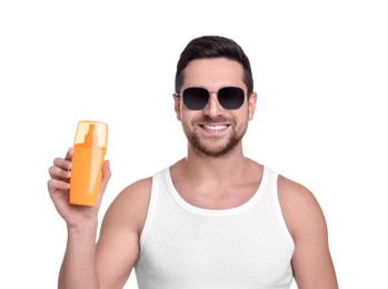 Photo of Handsome man in sunglasses holding bottle of sun protection cream on white background