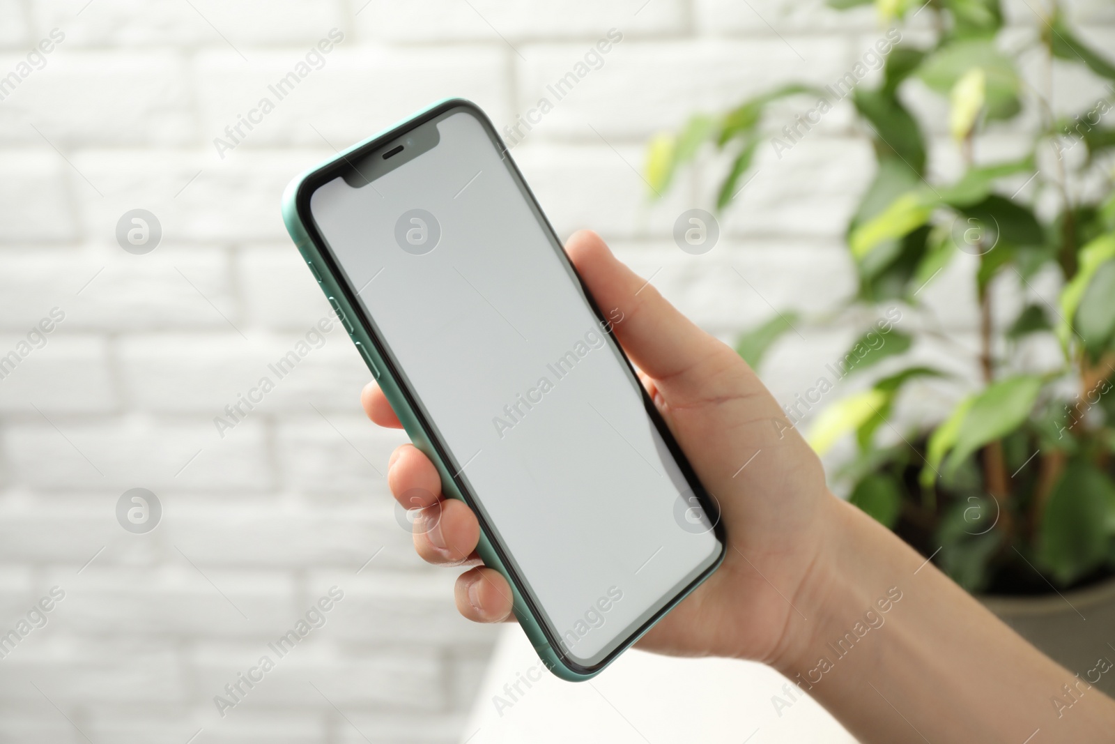 Photo of MYKOLAIV, UKRAINE - JULY 8, 2020: Woman holding Iphone 11 Pro Max with blank screen indoors, closeup