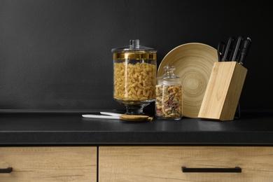Products and modern kitchen utensils on black table