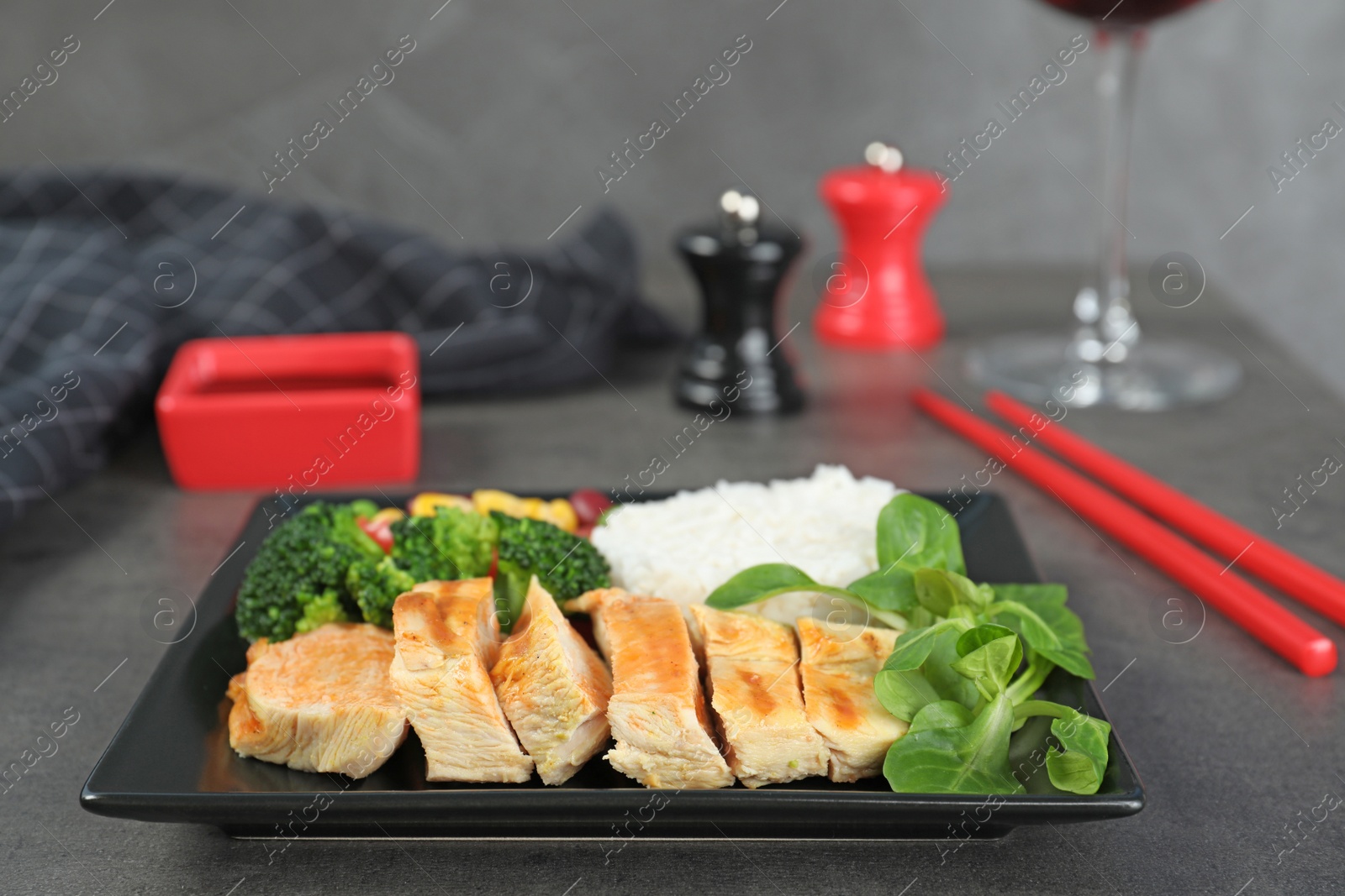 Photo of Plate of boiled rice with vegetables and meat served on table