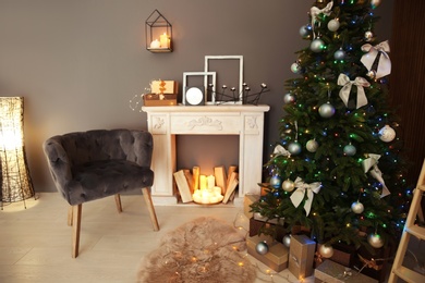 Photo of Stylish room interior with Christmas tree and decorative fireplace