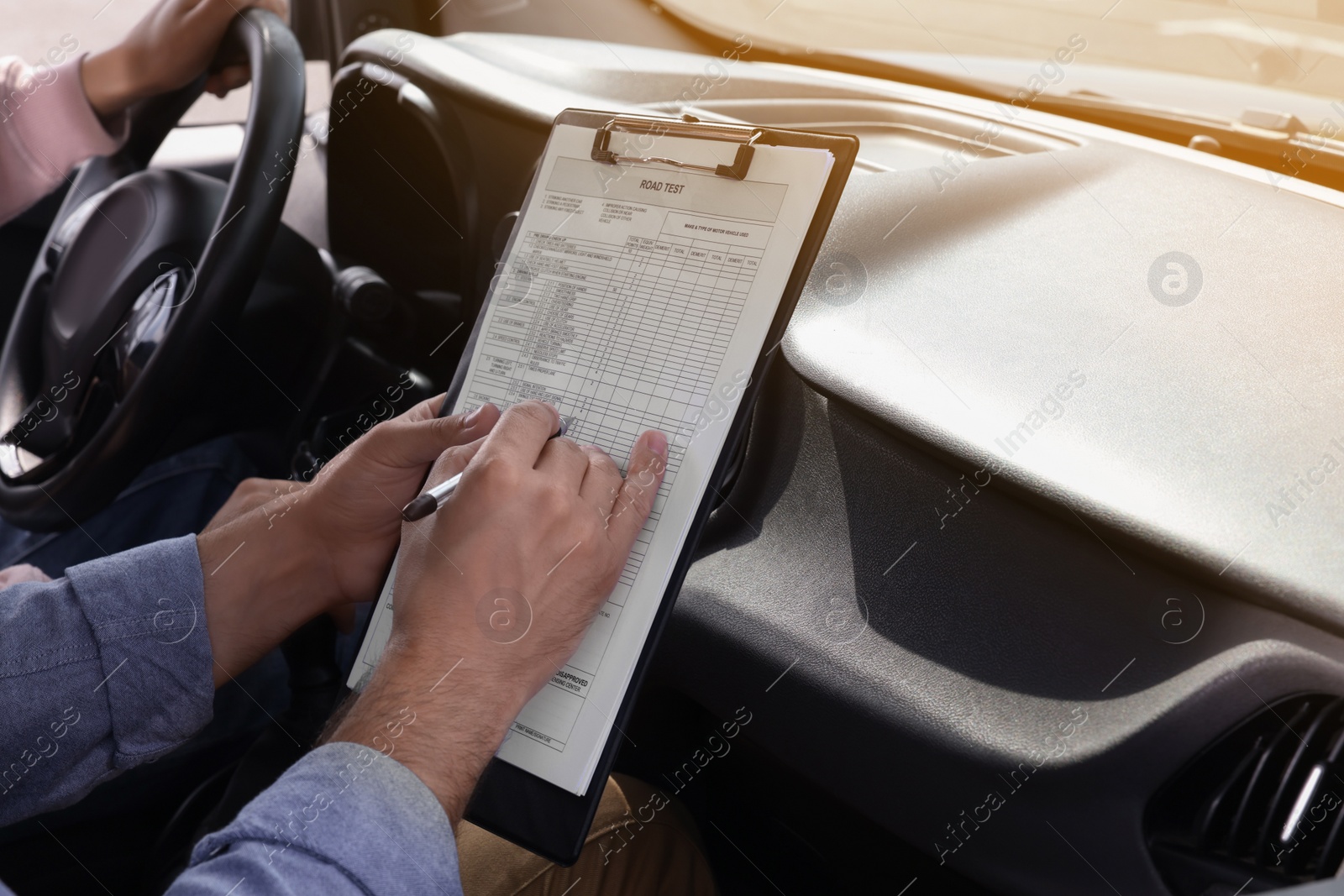 Photo of Driving school. Student passing driving test with examiner in car, closeup