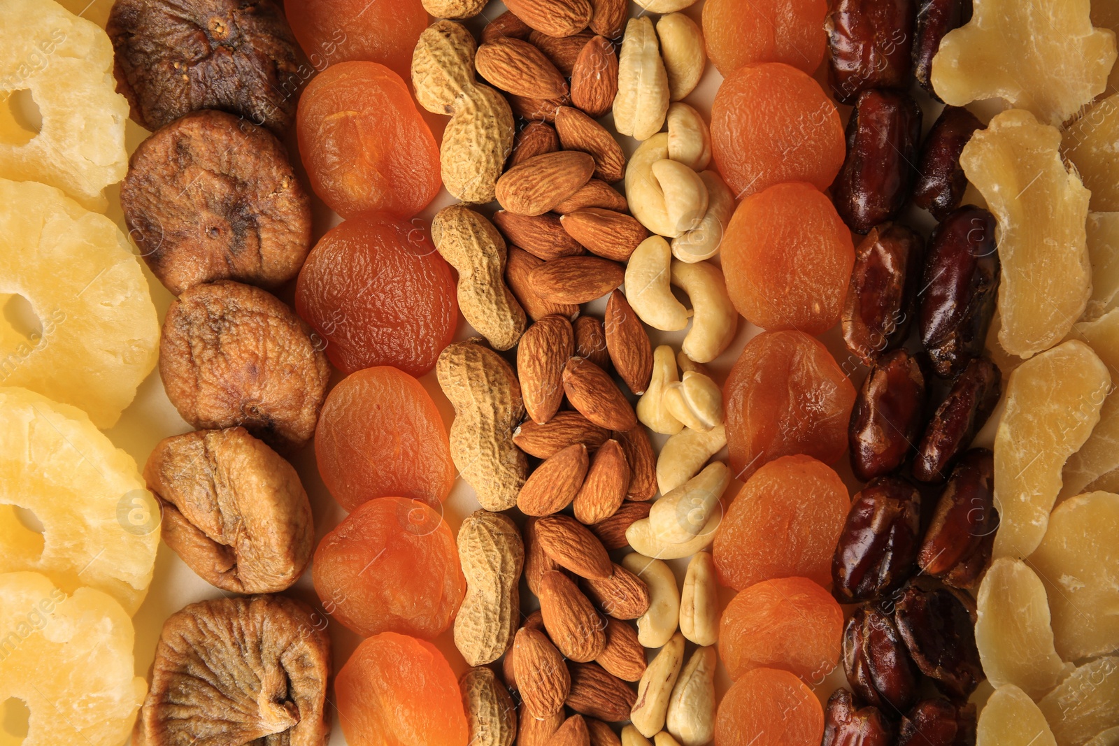 Photo of Different tasty nuts and dried fruits as background, top view