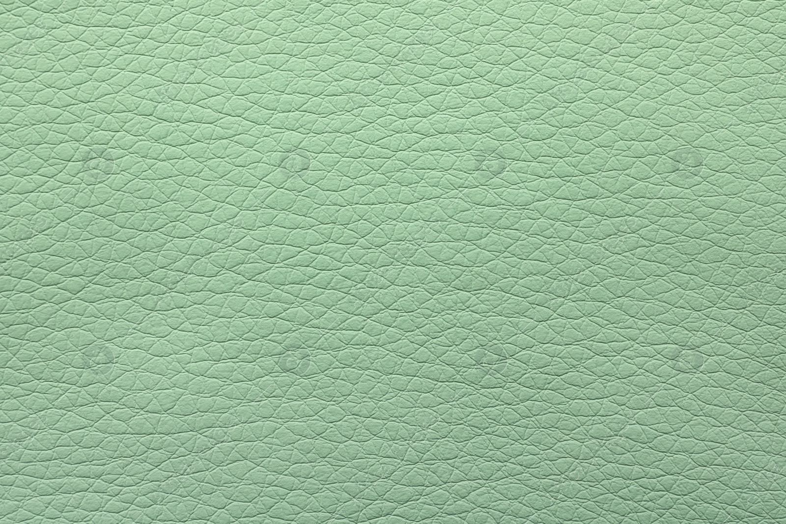 Photo of Texture of light green leather as background, closeup