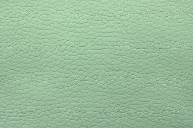 Photo of Texture of light green leather as background, closeup