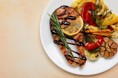 Tasty salmon steak with sauce, lemon and vegetables on light table, top view. Space for text