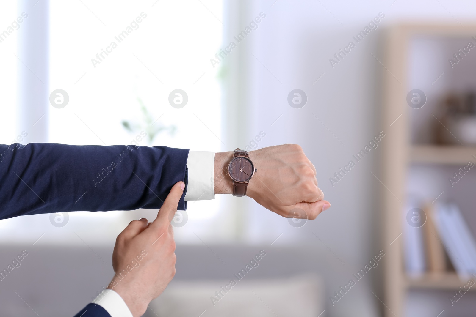 Photo of Businessman with wristwatch on blurred background, Time concept