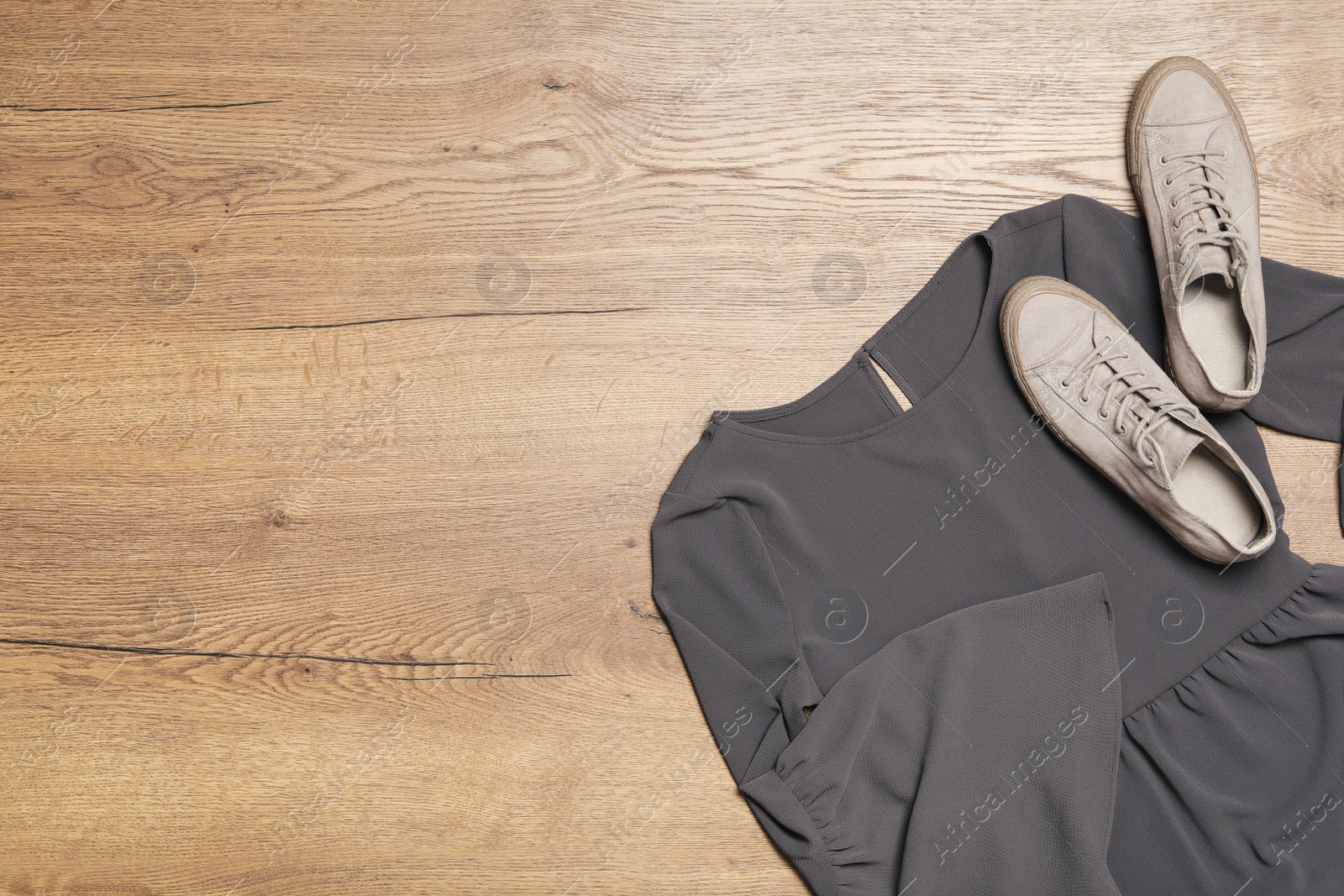 Photo of Stylish grey dress and shoes on wooden background, flat lay. Space for text