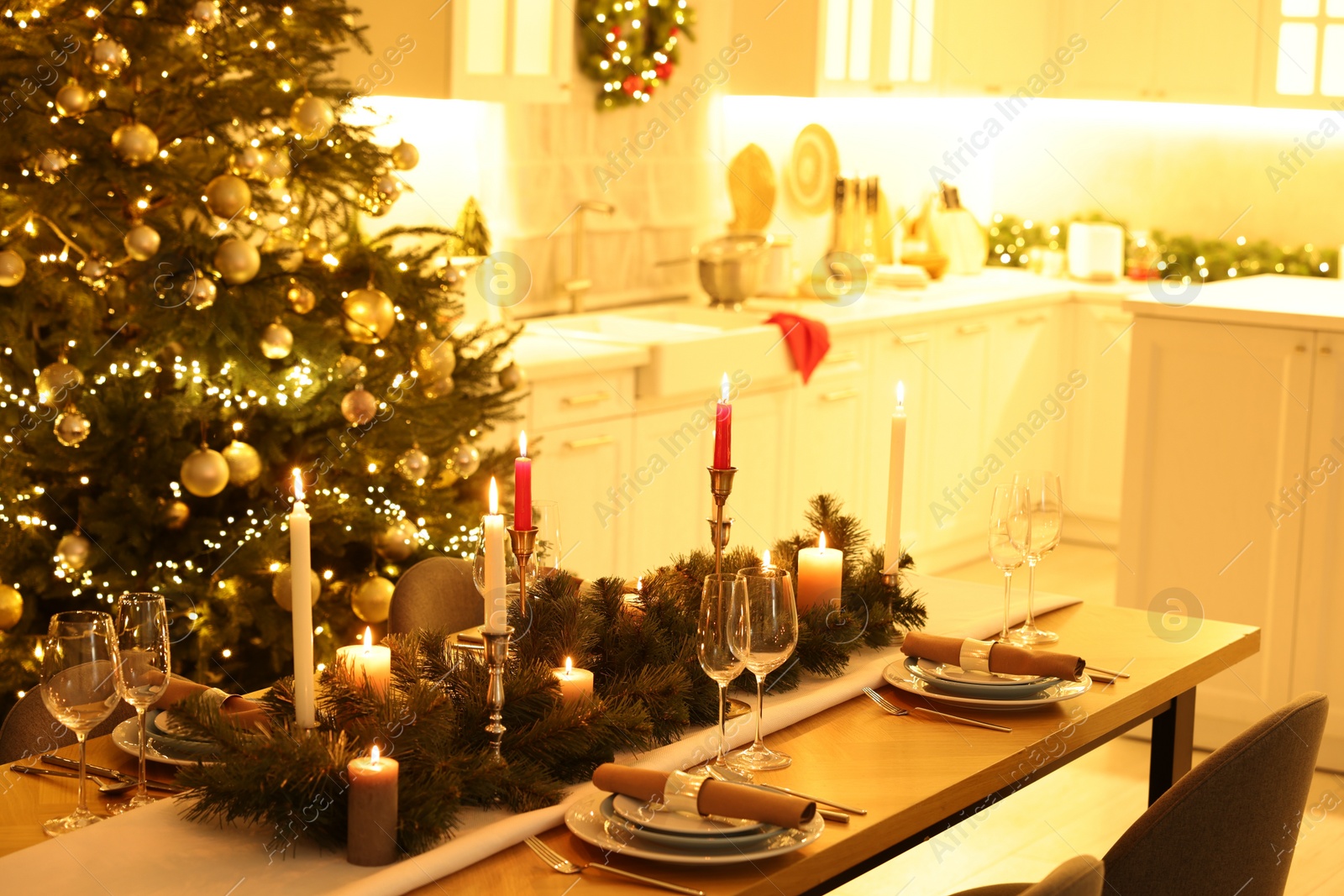 Photo of Festive table setting and beautiful Christmas decor in kitchen. Interior design