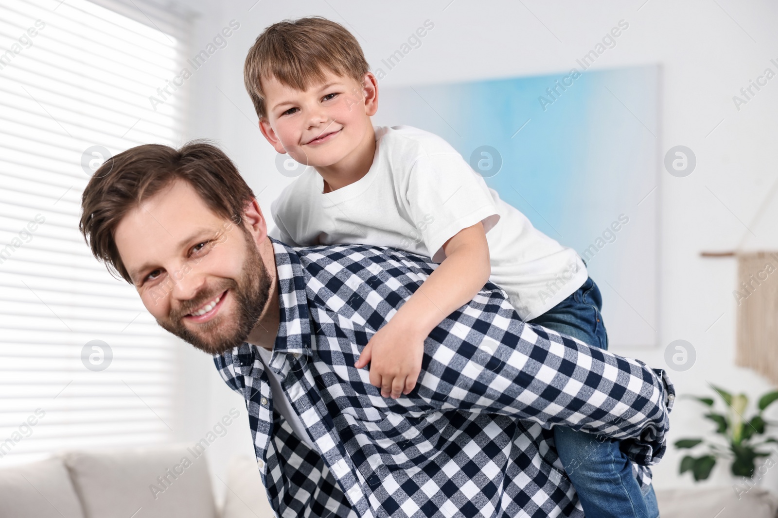 Photo of Happy dad and son having fun at home