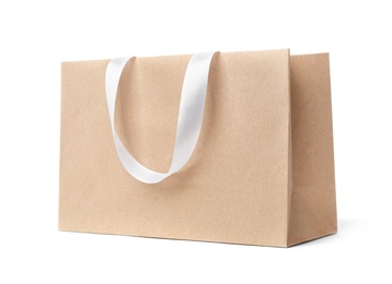 Photo of Paper shopping bag with ribbon handles on white background. Mockup for design