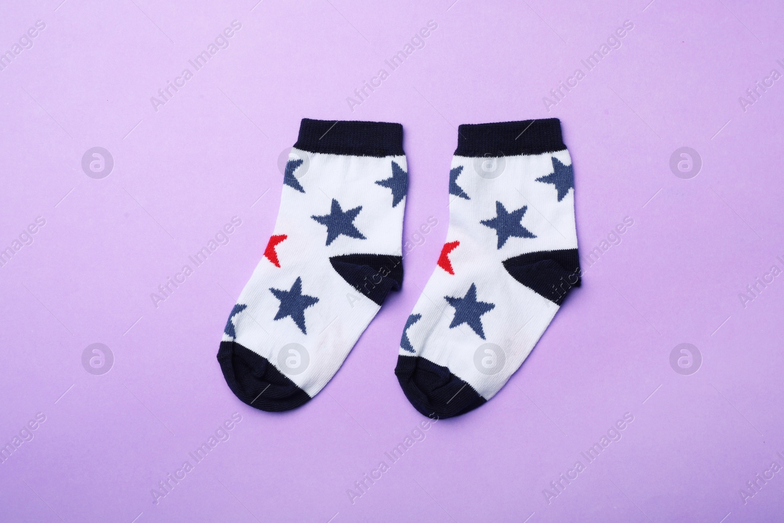 Photo of Cute child socks on color background, flat lay