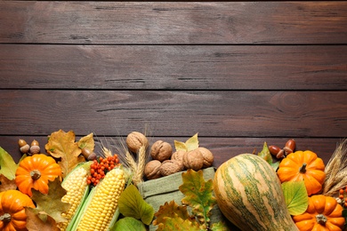 Flat lay composition with vegetables, nuts and autumn leaves on wooden table, space for text. Thanksgiving Day