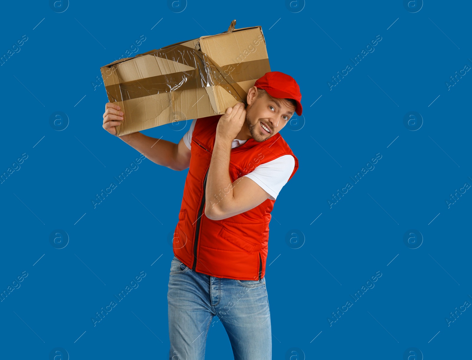Photo of Courier with damaged cardboard box on blue background. Poor quality delivery service
