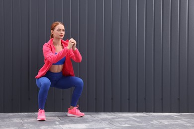 Photo of Beautiful woman in gym clothes doing exercises on street, space for text