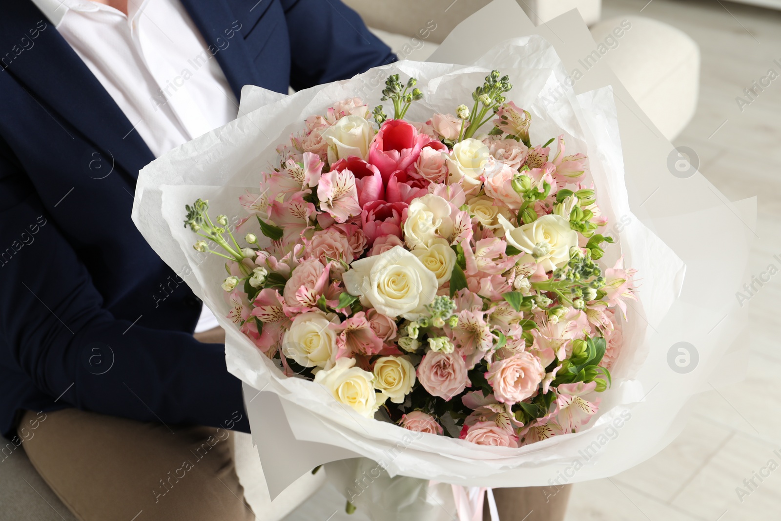 Photo of Man with beautiful bouquet of flowers indoors, closeup