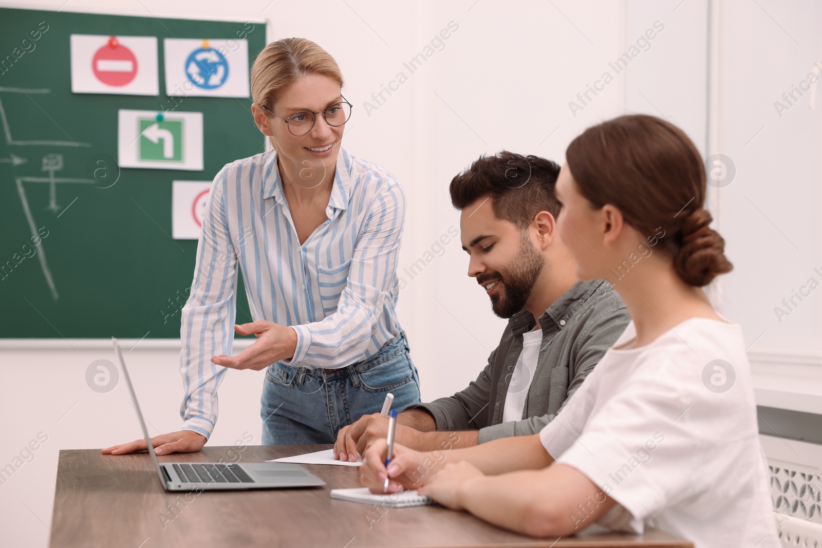 Photo of Happy teacher giving lesson in driving school