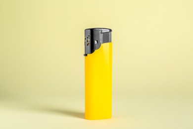 Stylish small pocket lighter on beige background