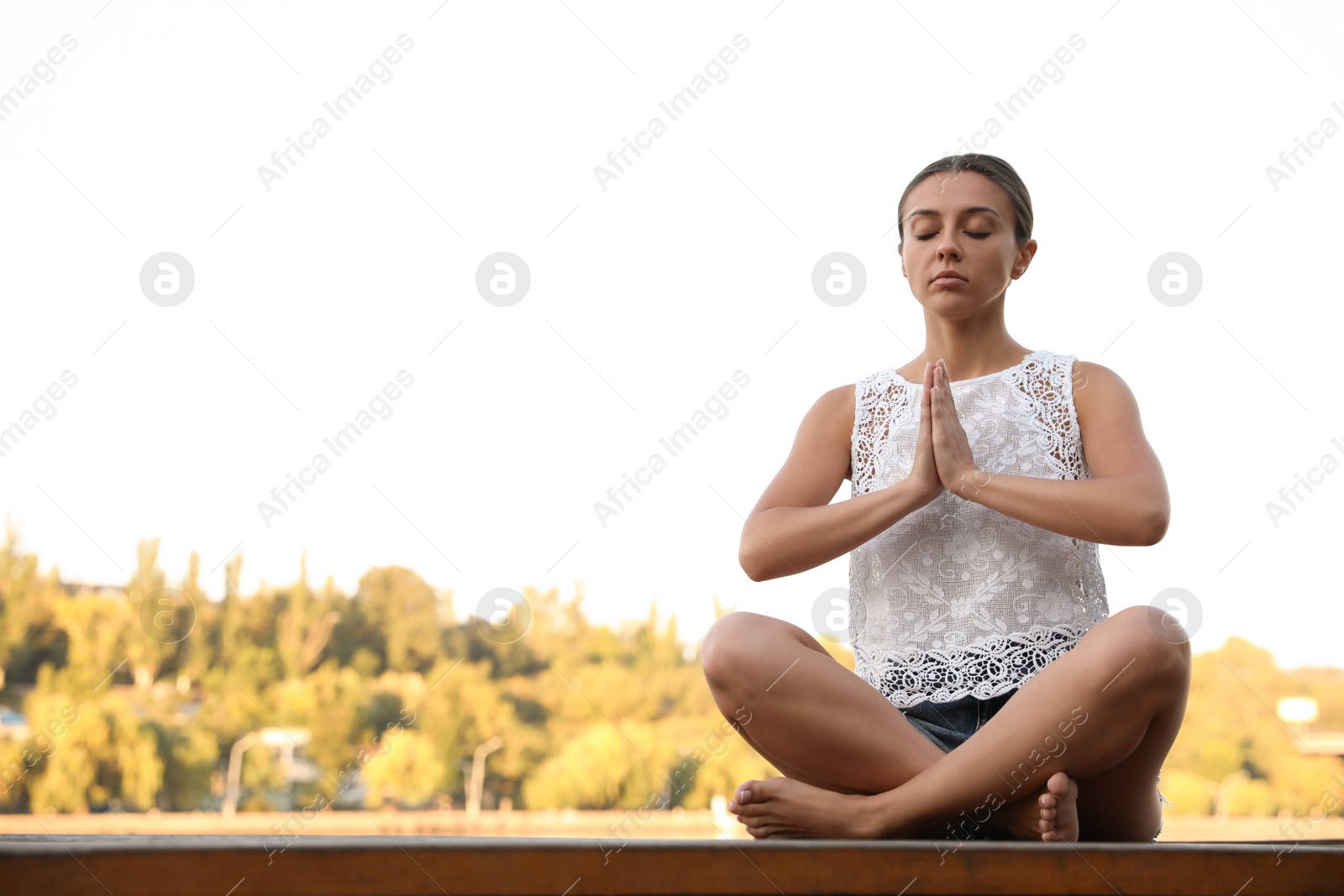 Photo of Young woman meditating at sunset. Nature healing power