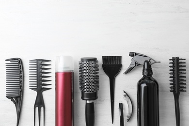 Photo of Flat lay composition with professional hairdresser tools on wooden background