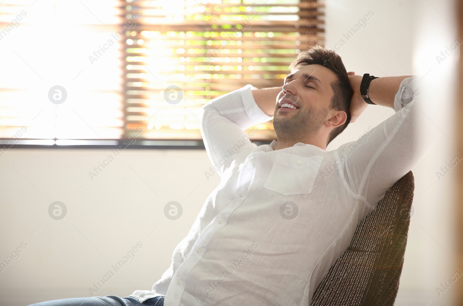 Photo of Young man relaxing near window at home. Space for text