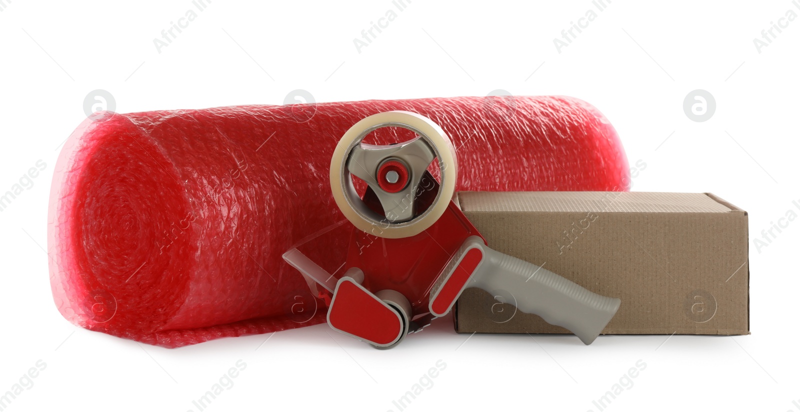 Photo of Bubble wrap roll, cardboard box and tape dispenser on white background