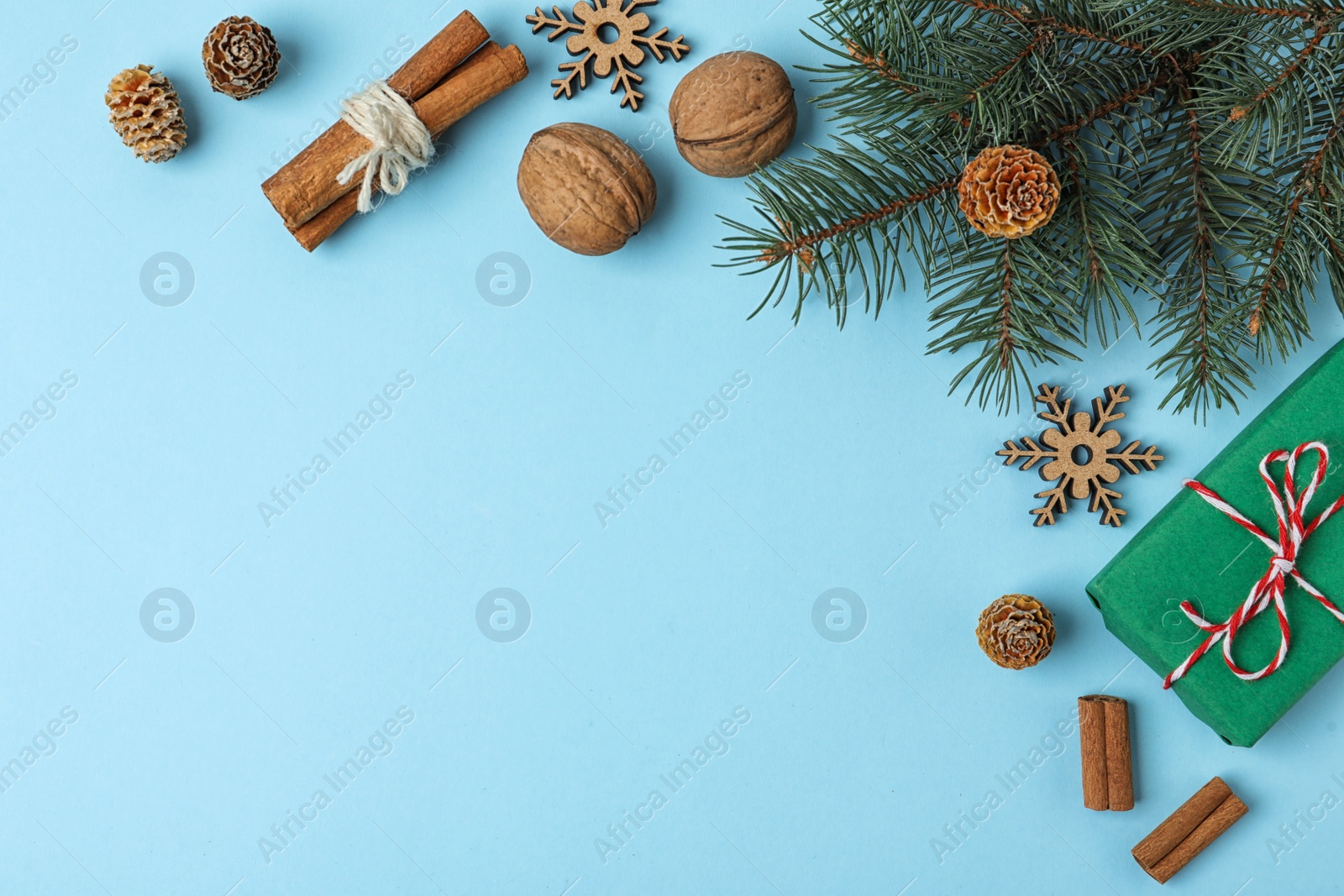 Photo of Flat lay composition with fir branch and gift box on light blue background, space for text. Winter holidays