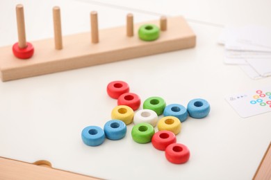 Photo of Stacking and counting game on table, closeup. Educational toy for motor skills development