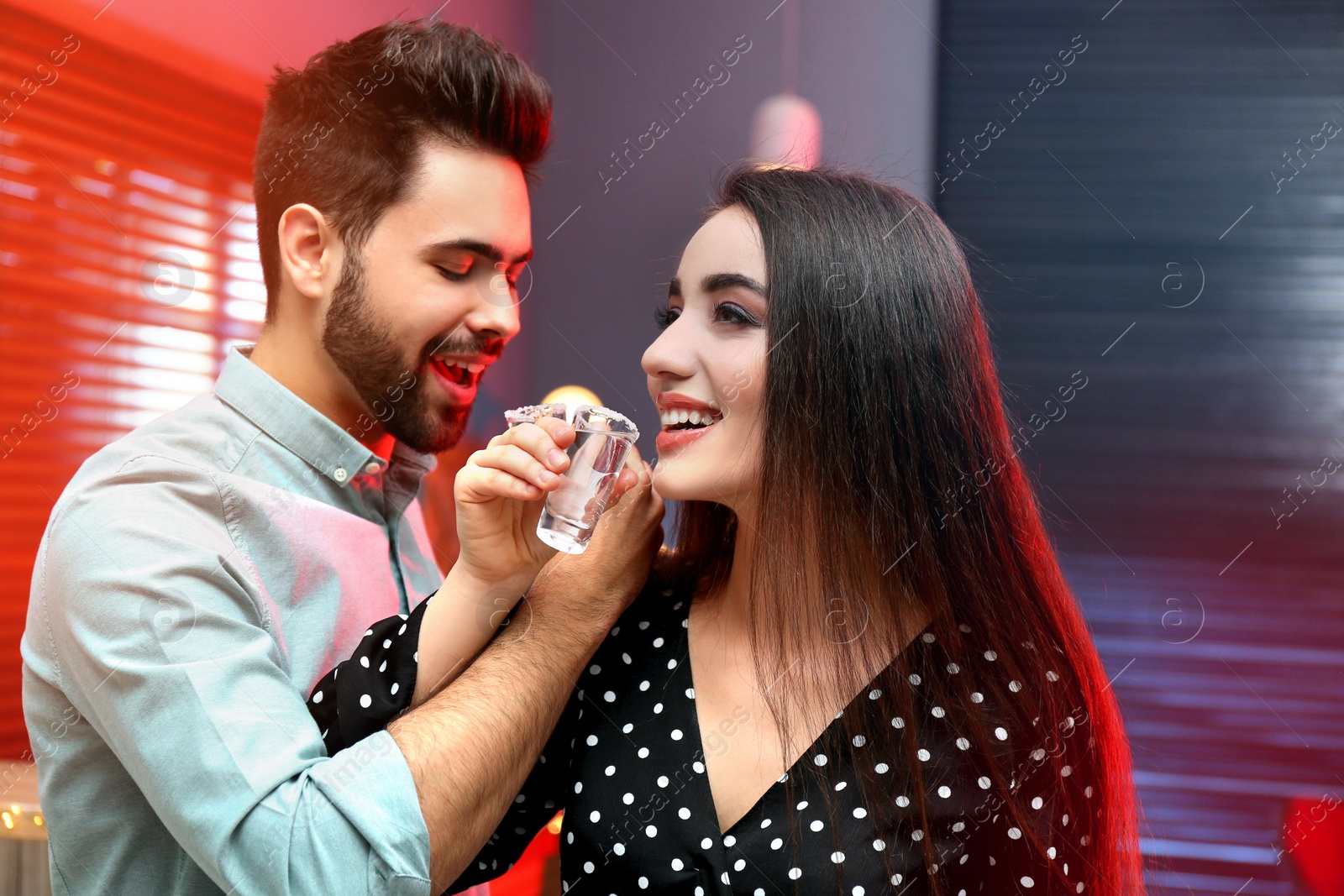Photo of Young couple drinking Mexican Tequila shots in bar
