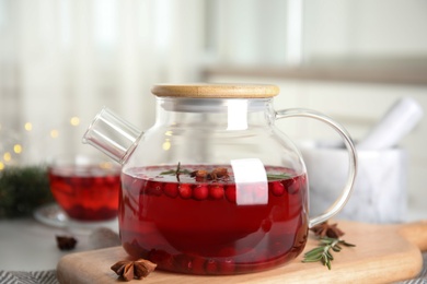 Photo of Tasty hot cranberry tea with rosemary and anise on table