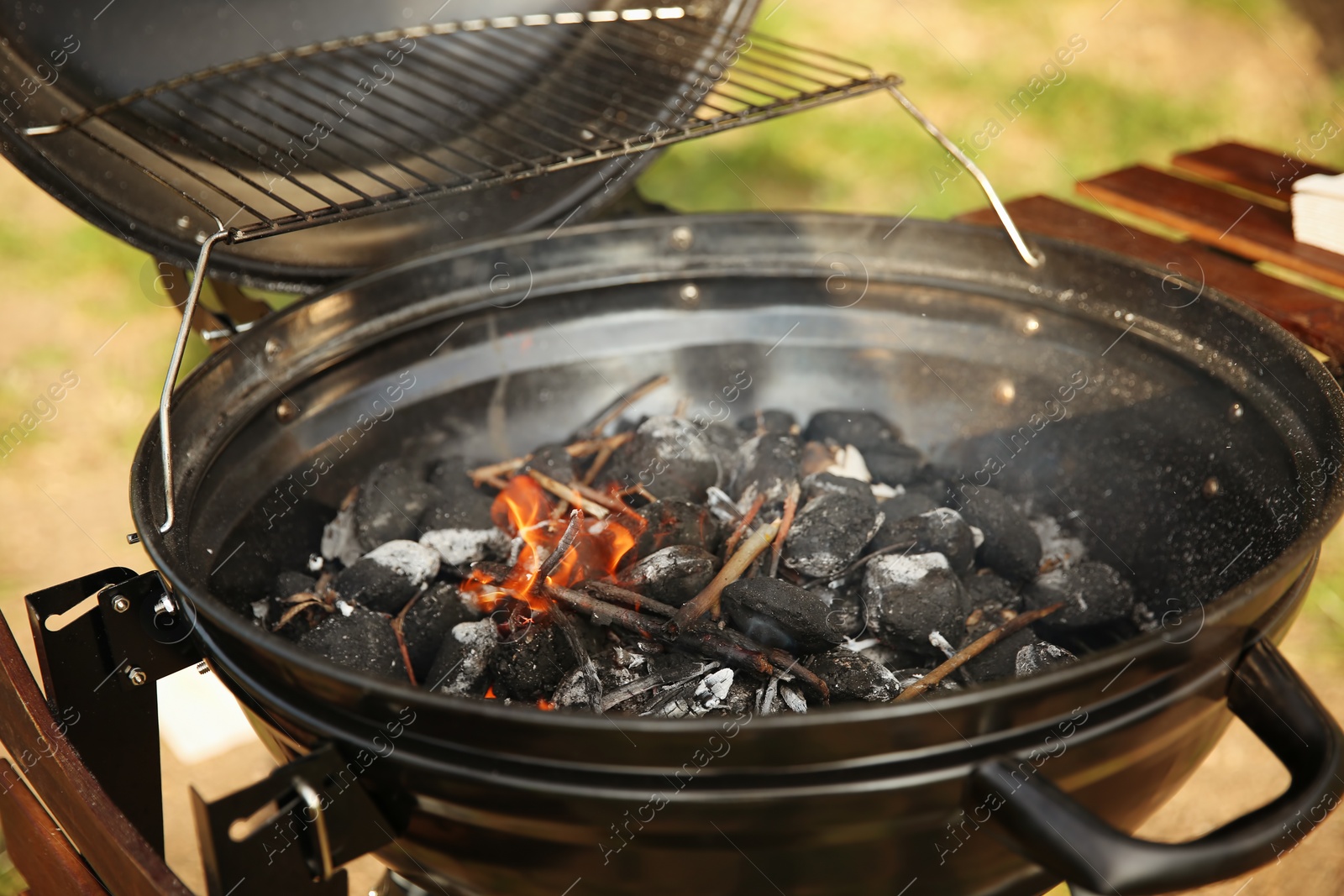 Photo of Modern barbecue grill with coals outdoors. Camping cookout