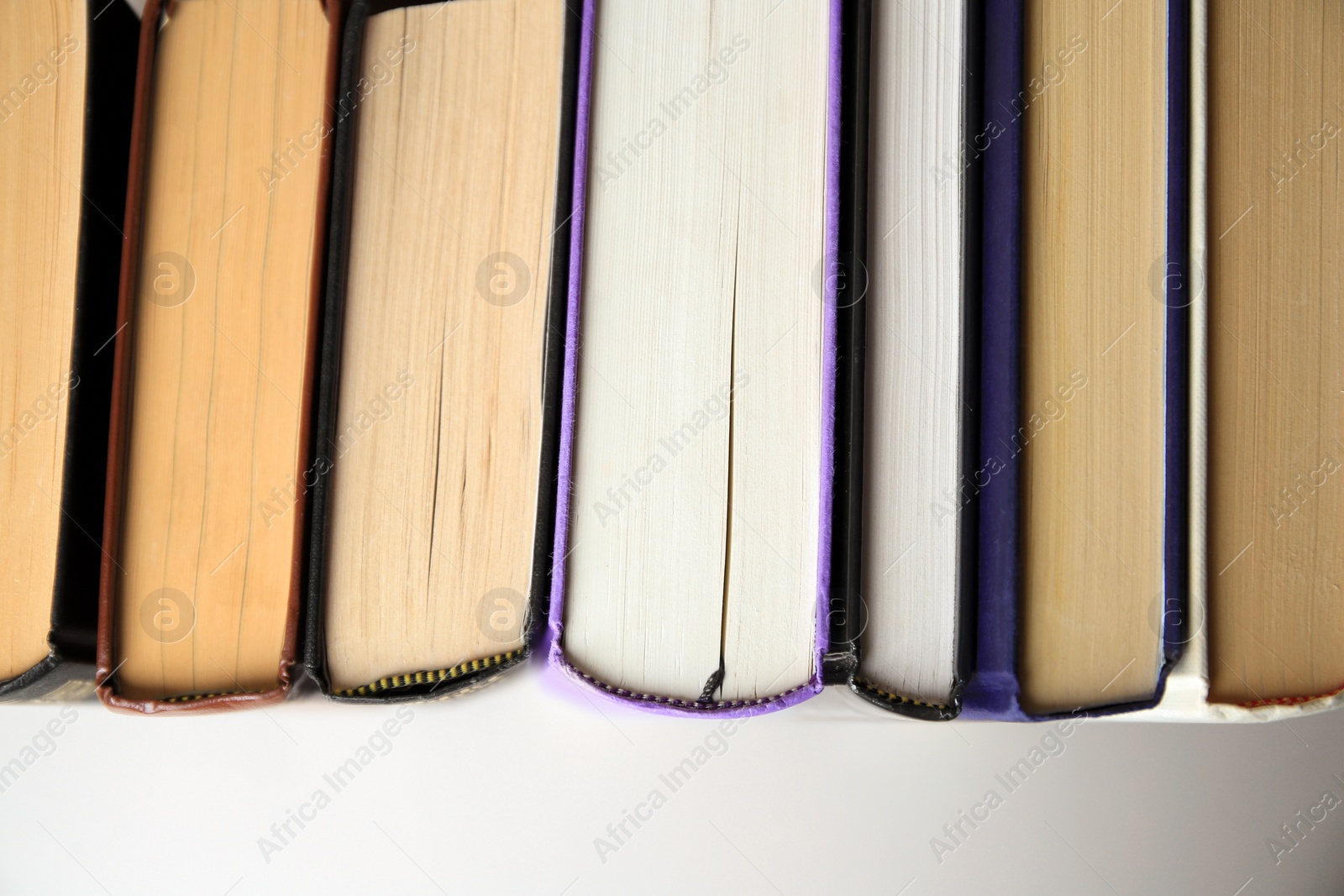 Photo of Collection of different books on white shelf, top view