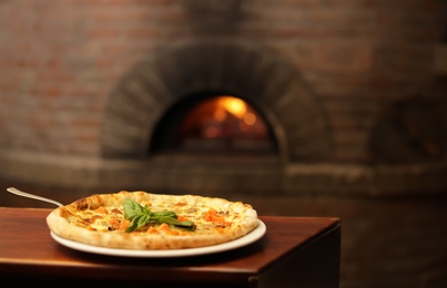 Photo of Tasty oven baked pizza on wooden table. Space for text