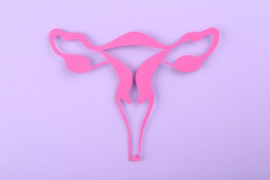 Photo of Reproductive medicine. Paper uterus on violet background, top view