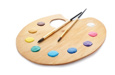 Photo of Palette with paints and brushes on white background