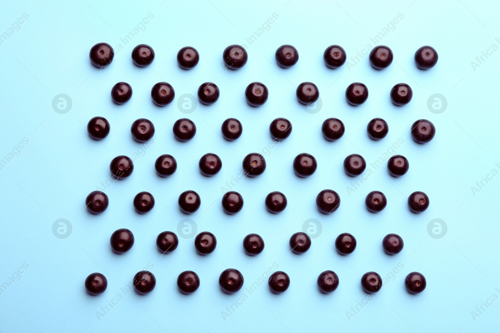 Photo of Fresh acai berries on light blue background, flat lay