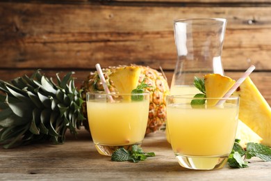 Delicious fresh pineapple juice with mint on wooden table